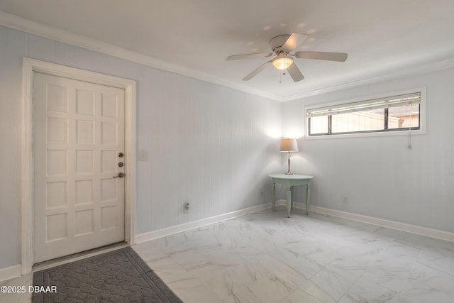 spare room featuring ornamental molding, marble finish flooring, a ceiling fan, and baseboards