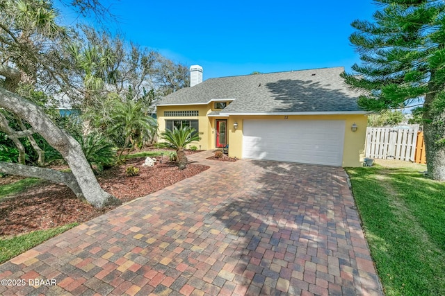 ranch-style house featuring decorative driveway, fence, an attached garage, and stucco siding