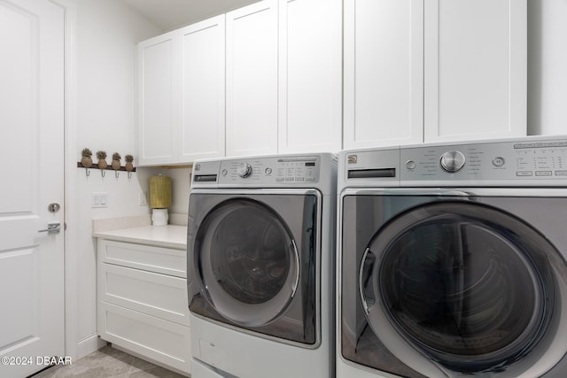 clothes washing area with cabinets, separate washer and dryer, and light tile patterned floors