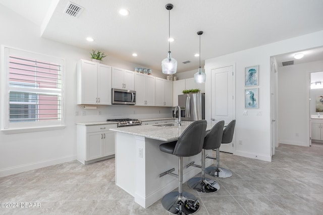 kitchen featuring white cabinetry, a center island with sink, stainless steel appliances, and sink