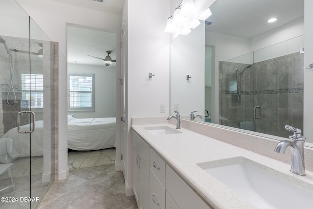 bathroom with tile patterned floors, ceiling fan, a shower with door, and vanity