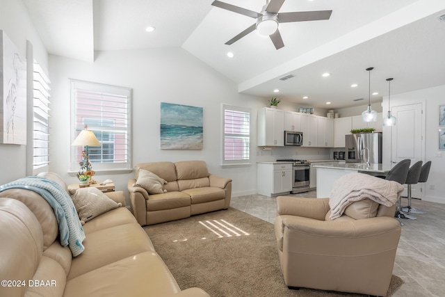 living room with ceiling fan, light tile patterned flooring, a healthy amount of sunlight, and vaulted ceiling