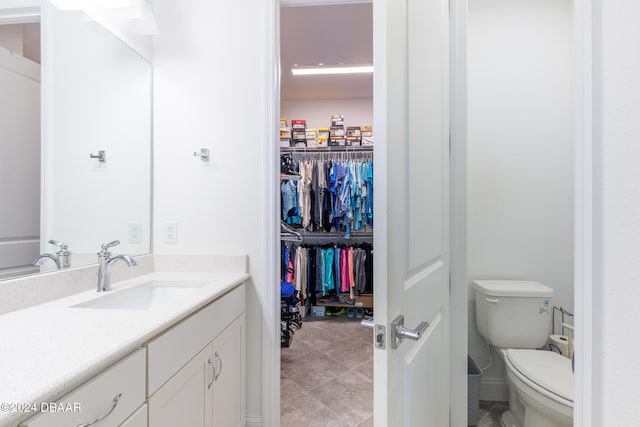 bathroom with tile patterned flooring, vanity, and toilet