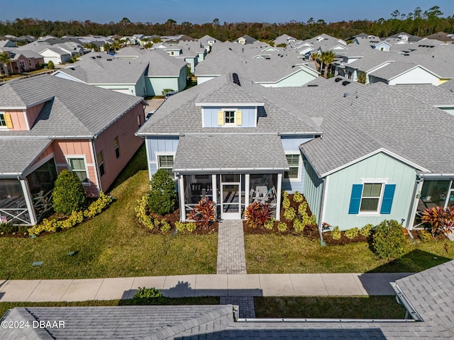 view of front of house featuring a sunroom and a front yard