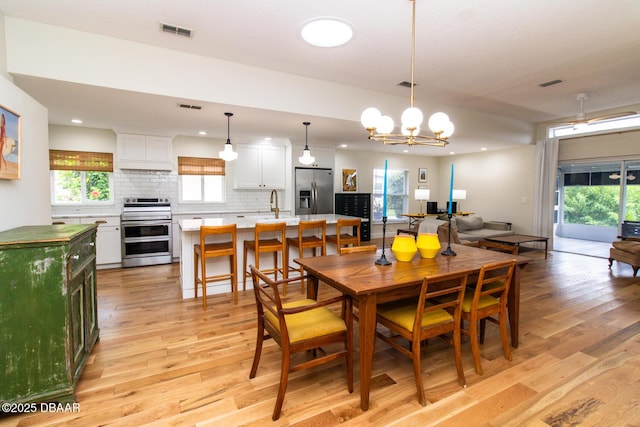 1327 Wayne Ave, New Smyrna Beach, FL 32168 - dining space featuring light wood-type flooring, a chandelier, recessed lighting, and plenty of natural light