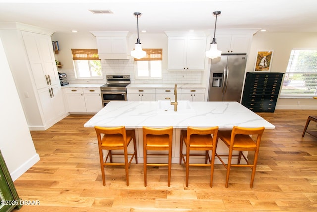 1327 Wayne Ave, New Smyrna Beach, FL 32168 - kitchen with stainless steel appliances, light wood-style flooring, white cabinetry, and recessed lighting