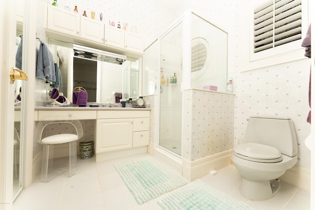 bathroom with tile patterned flooring, vanity, toilet, and a shower with shower door