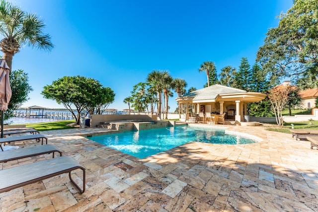 view of swimming pool with an in ground hot tub, a water view, and a patio area