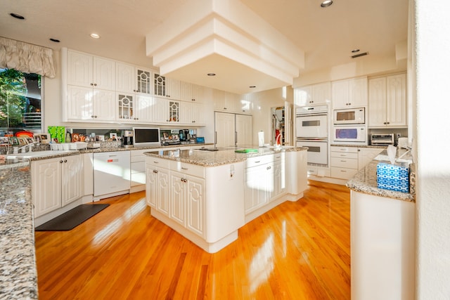 kitchen featuring white cabinets, white appliances, and a center island