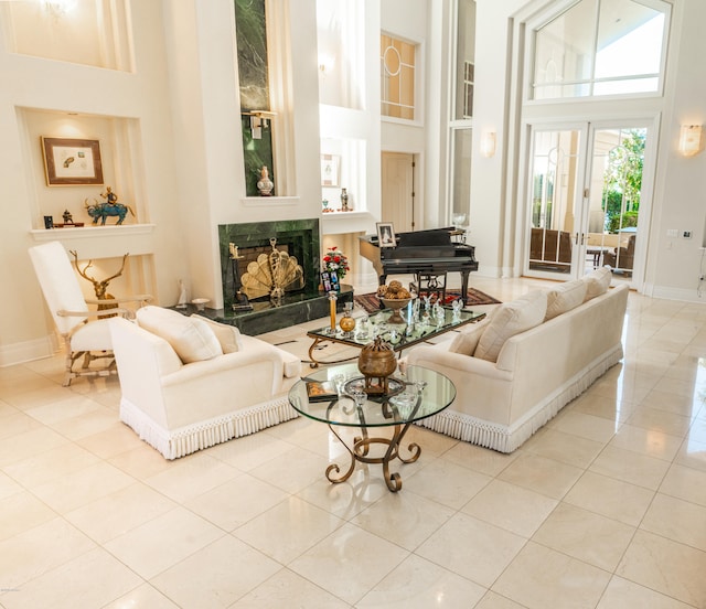 living room with a fireplace, light tile patterned floors, and a high ceiling