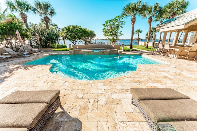 view of pool featuring a water view, an in ground hot tub, and a patio area