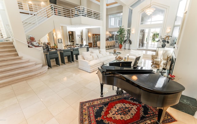 interior space with french doors, a towering ceiling, and light tile patterned flooring