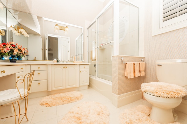 full bathroom featuring toilet, vanity, tile patterned floors, and enclosed tub / shower combo