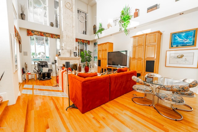 living room with a high ceiling and light hardwood / wood-style flooring