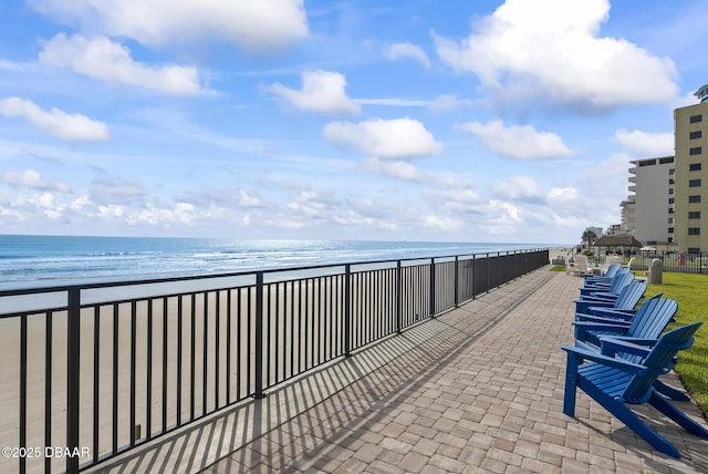 view of patio with a beach view and a water view