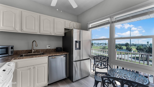 kitchen featuring white cabinetry, appliances with stainless steel finishes, sink, and light hardwood / wood-style flooring