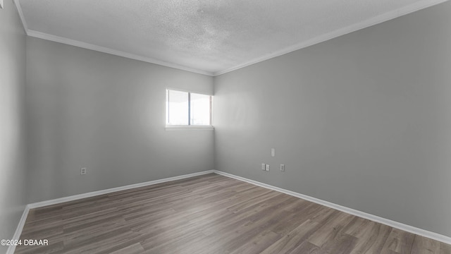 unfurnished room with a textured ceiling, hardwood / wood-style floors, and crown molding