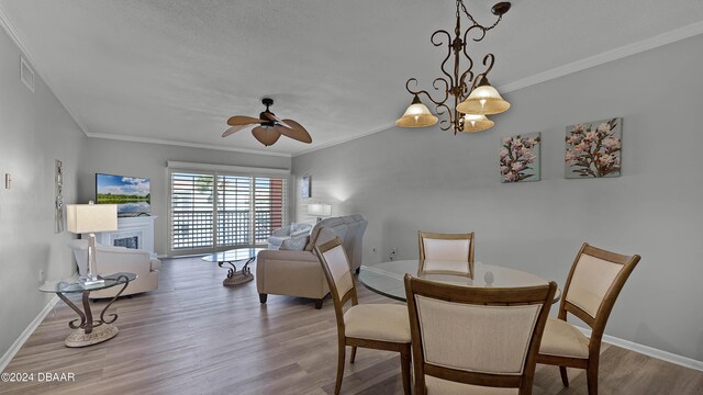 interior space featuring light hardwood / wood-style floors, ceiling fan with notable chandelier, and crown molding