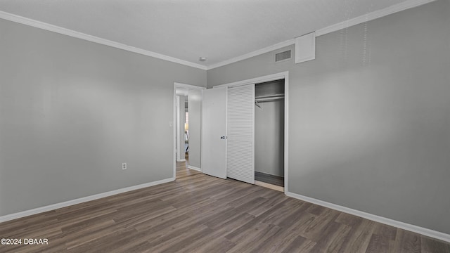 unfurnished bedroom featuring ornamental molding, hardwood / wood-style floors, and a closet