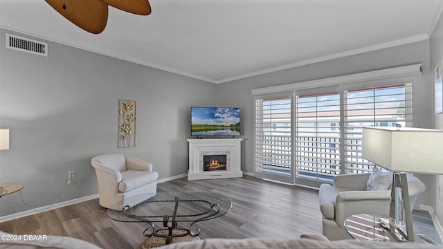 living room with ceiling fan, wood-type flooring, and ornamental molding