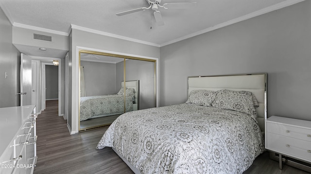 bedroom featuring dark wood-type flooring, a closet, ornamental molding, and ceiling fan