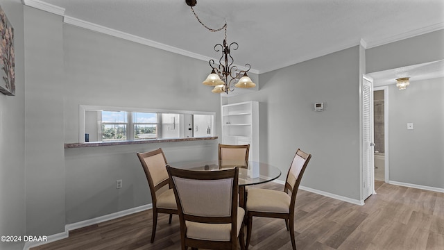 dining room featuring ornamental molding, wood-type flooring, and a chandelier