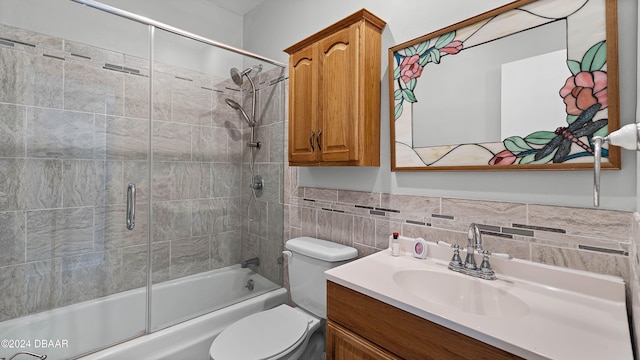 full bathroom with toilet, combined bath / shower with glass door, vanity, and tile walls