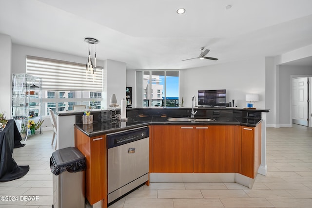 kitchen featuring dishwasher, decorative light fixtures, an island with sink, and a healthy amount of sunlight