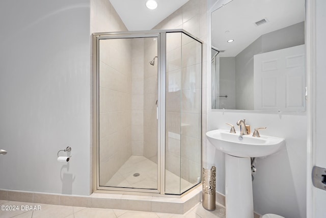 bathroom featuring tile patterned flooring and an enclosed shower