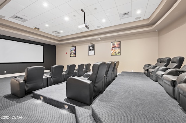 carpeted home theater room with a paneled ceiling and a raised ceiling