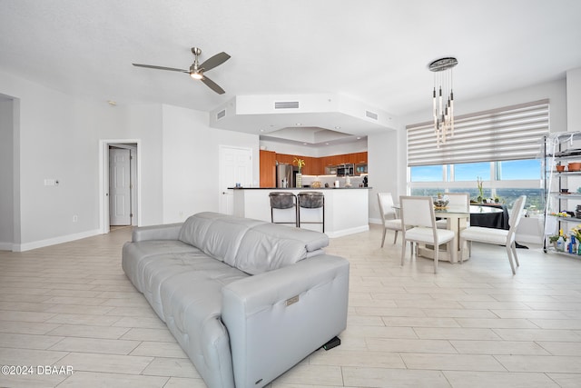 living room with ceiling fan with notable chandelier
