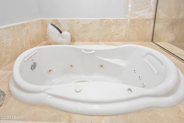 bathroom with tile walls and tiled tub