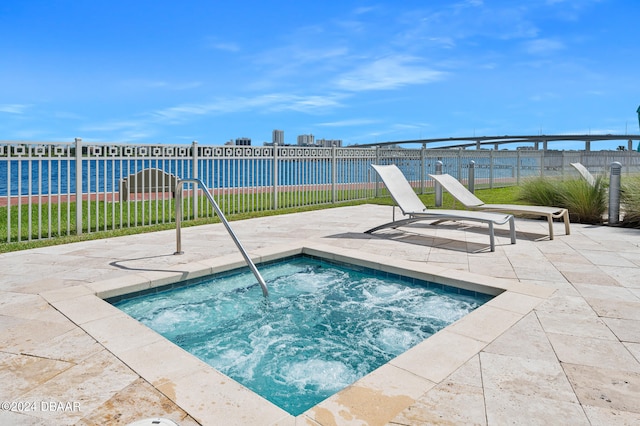 view of swimming pool with an in ground hot tub and a water view