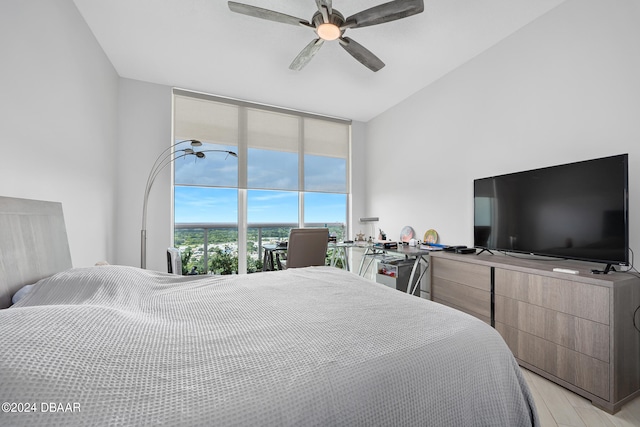 bedroom featuring expansive windows, access to outside, light hardwood / wood-style floors, and ceiling fan