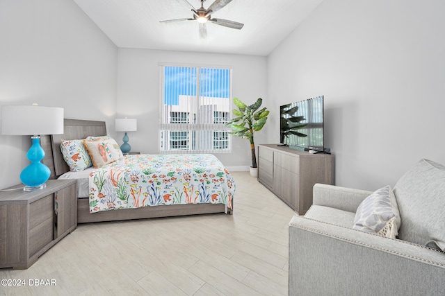 bedroom featuring ceiling fan, light hardwood / wood-style flooring, and lofted ceiling