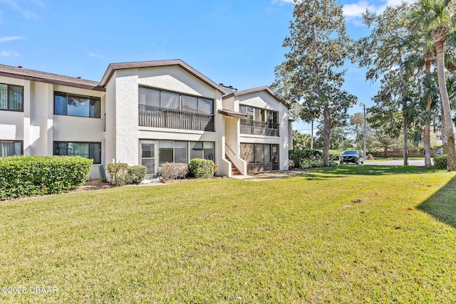 1 Tomoka Oaks Blvd Unit 112, Ormond Beach, FL 32174 - back of property with stucco siding and a lawn