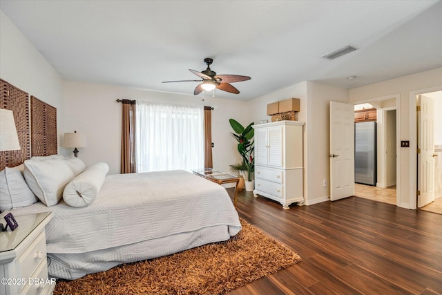 bedroom featuring ceiling fan, dark hardwood / wood-style floors, and stainless steel refrigerator