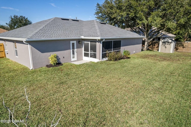 back of house featuring a storage shed, a yard, and a sunroom