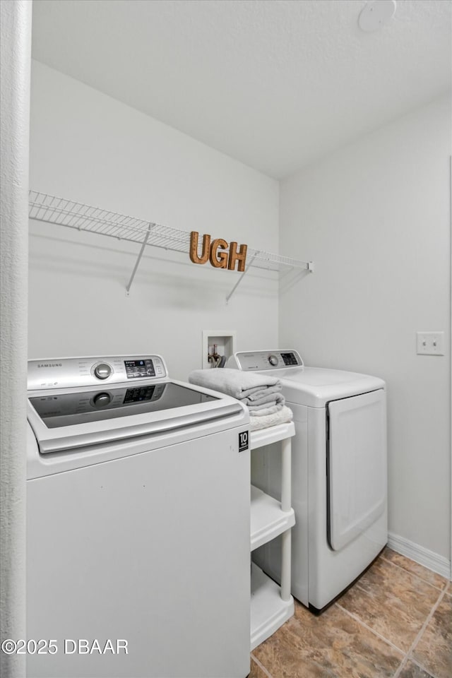 clothes washing area with washer and clothes dryer