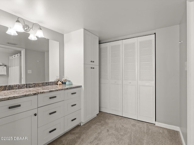full bathroom featuring a closet, carpet, vanity, and a chandelier