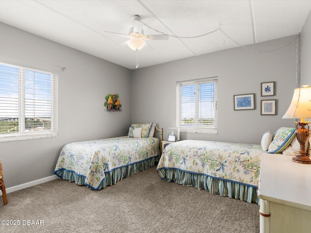 carpeted bedroom featuring multiple windows, a ceiling fan, and baseboards