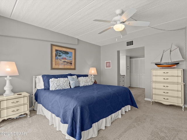 bedroom with carpet flooring, a closet, ceiling fan, and a textured ceiling