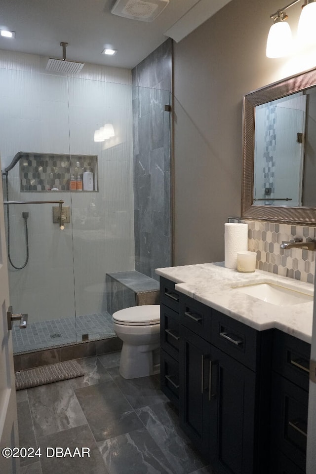 bathroom featuring decorative backsplash, toilet, an enclosed shower, and vanity