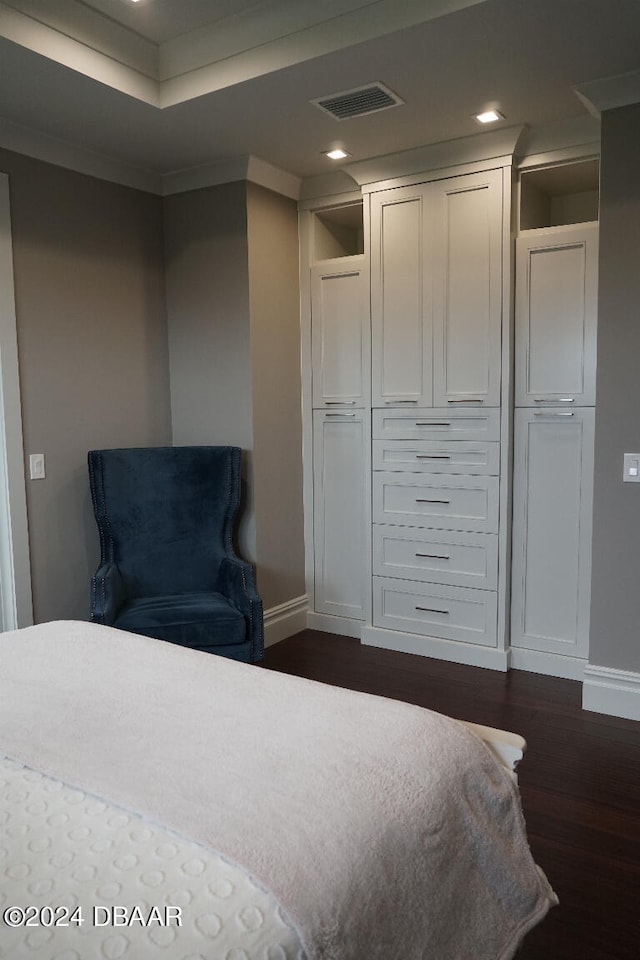 bedroom featuring crown molding, a closet, and dark wood-type flooring