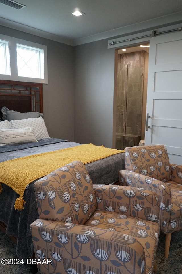 bedroom with carpet flooring, a barn door, and crown molding