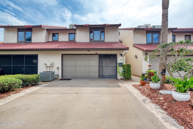 mediterranean / spanish-style house with a garage and cooling unit