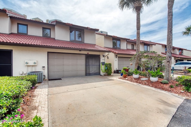 view of front of home featuring central AC unit and a garage