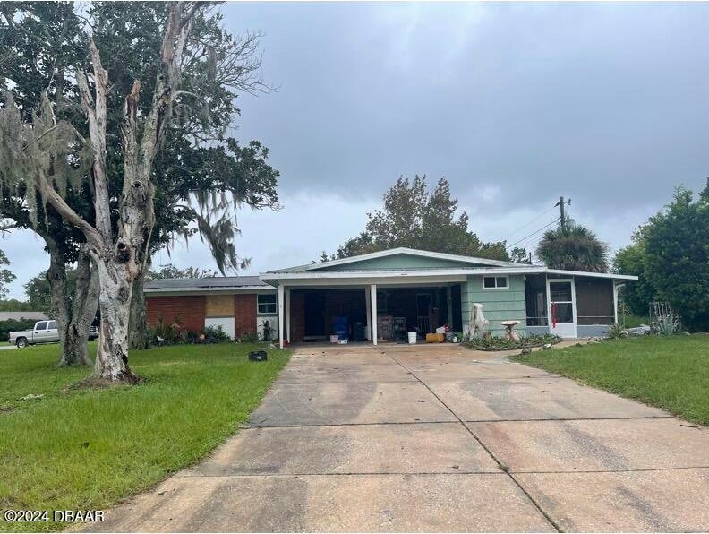 single story home with a carport and a front lawn