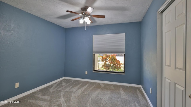 spare room with carpet, a ceiling fan, baseboards, and a textured ceiling