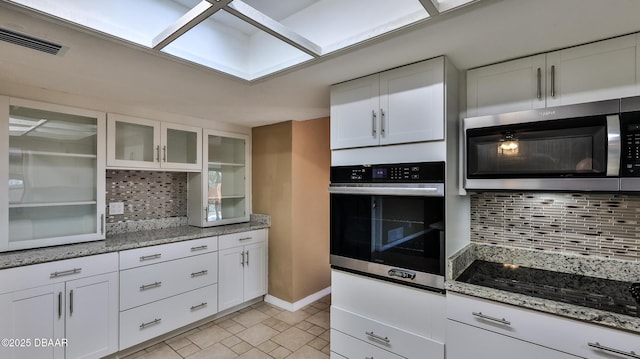 kitchen featuring tasteful backsplash, visible vents, stainless steel appliances, and white cabinetry
